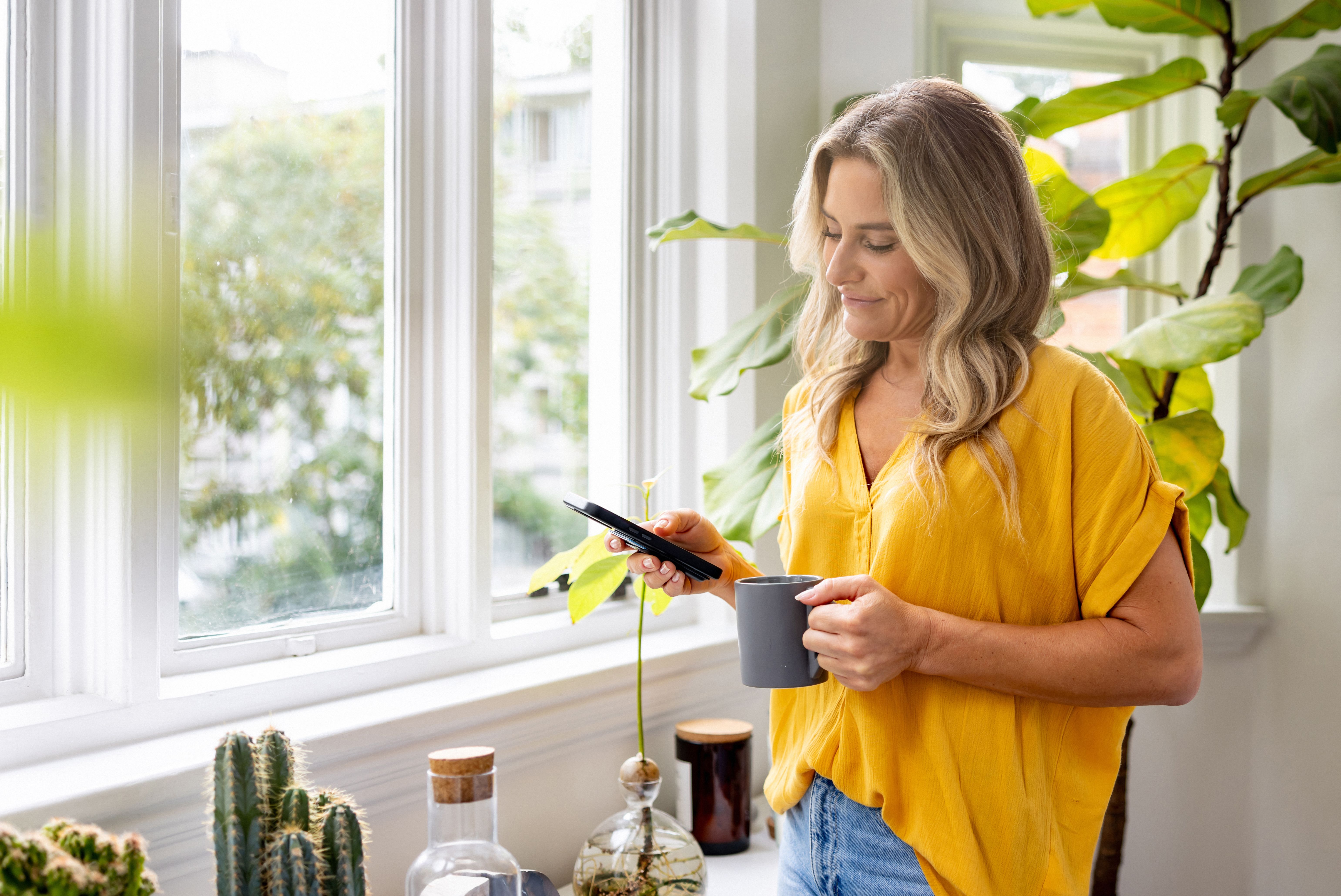 Frau nutzt ein Smartphone zu Hause – Symbolbild für Online-Partnersuche und erste Kontakte.