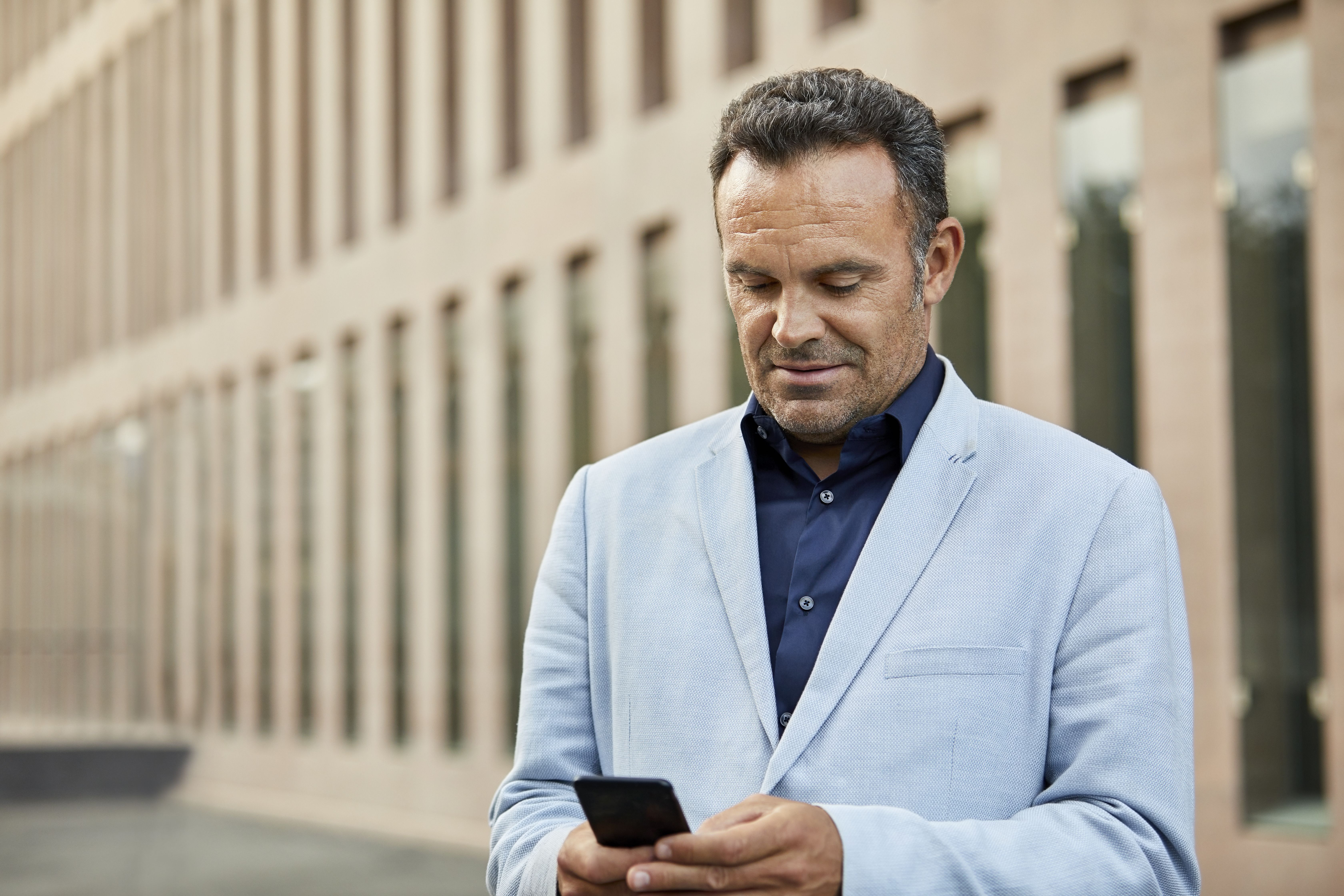 Ein Mann schreibt an seinem Mobiltelefon. 